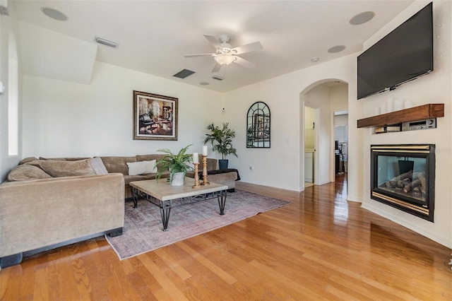 living room featuring wood-type flooring and ceiling fan