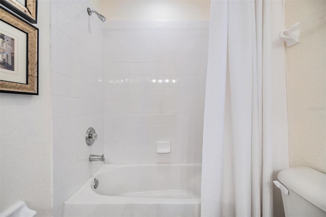 bathroom featuring toilet and shower / bathtub combination with curtain