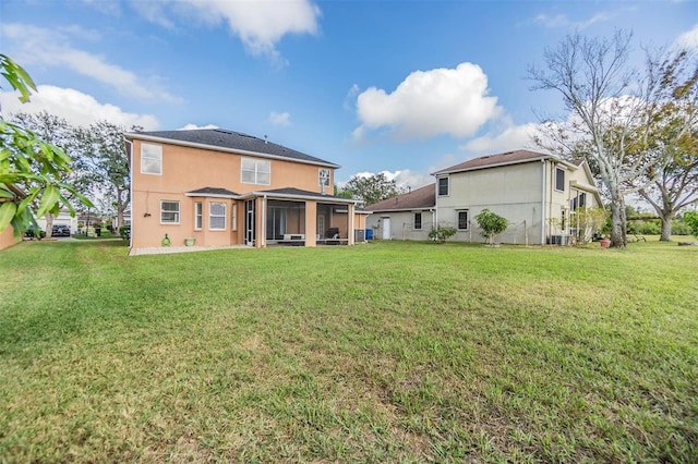 back of property with a sunroom, a yard, and central air condition unit