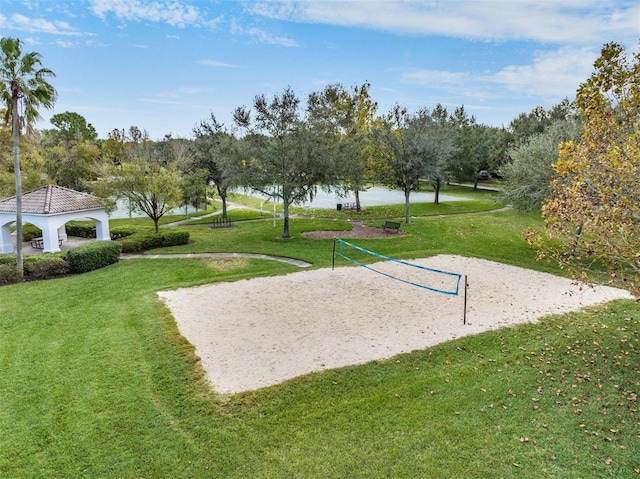 surrounding community with volleyball court, a lawn, a water view, and a gazebo