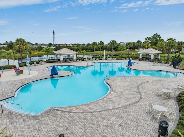 view of pool with a gazebo, a patio area, and a water view