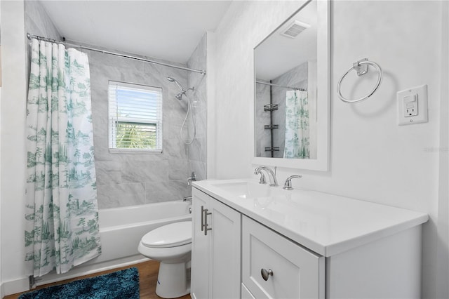 full bath featuring vanity, wood finished floors, visible vents, shower / tub combo, and toilet