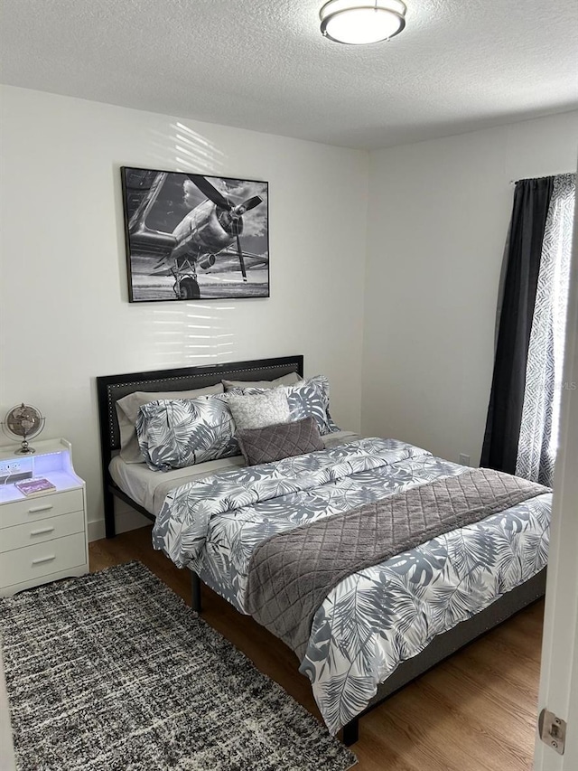 bedroom featuring a textured ceiling and wood finished floors