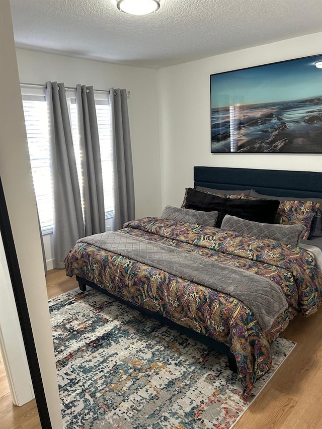 bedroom with wood finished floors and a textured ceiling