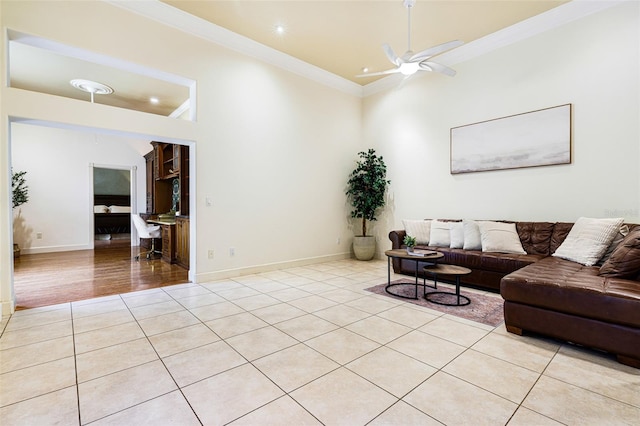 living room featuring ceiling fan, ornamental molding, and light hardwood / wood-style flooring