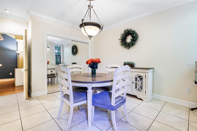 dining area featuring light tile patterned floors and crown molding