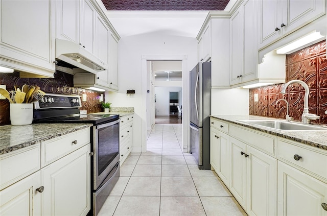 kitchen featuring sink, vaulted ceiling, light tile patterned flooring, white cabinetry, and stainless steel appliances