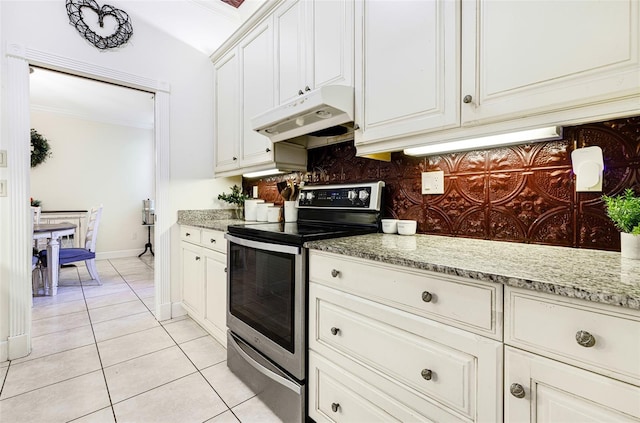 kitchen with stainless steel electric range, light stone countertops, light tile patterned floors, tasteful backsplash, and white cabinetry