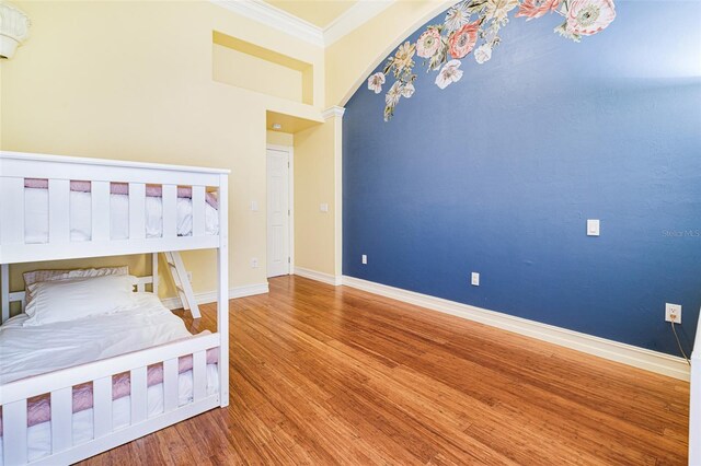 unfurnished bedroom with ornamental molding and hardwood / wood-style flooring