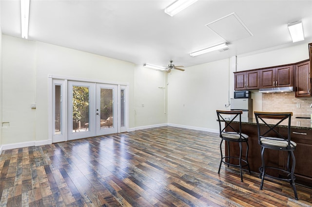 kitchen featuring a breakfast bar, dark hardwood / wood-style flooring, tasteful backsplash, and ceiling fan