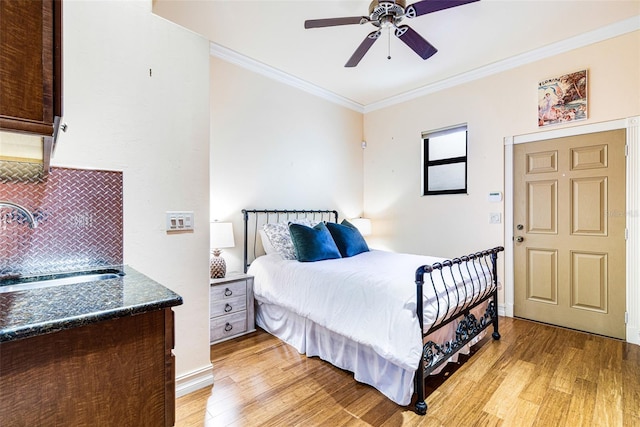 bedroom with ceiling fan, sink, light hardwood / wood-style floors, and ornamental molding