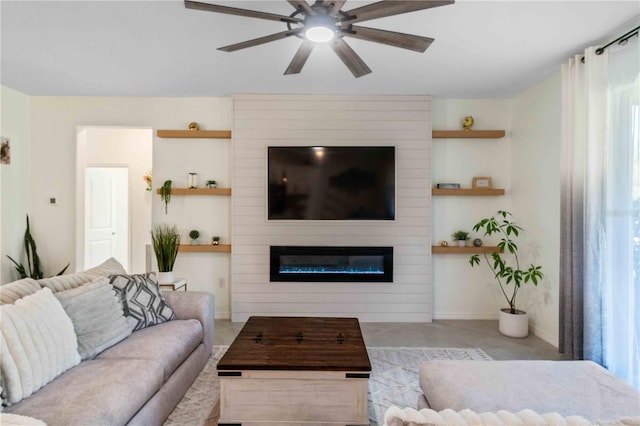 living area featuring a large fireplace and ceiling fan