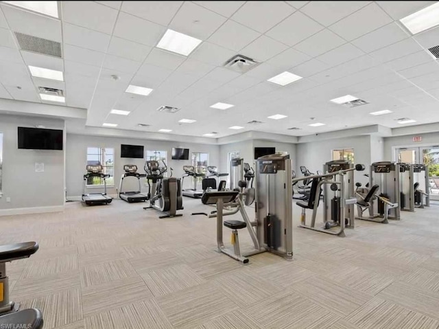 exercise room featuring visible vents, light colored carpet, and baseboards