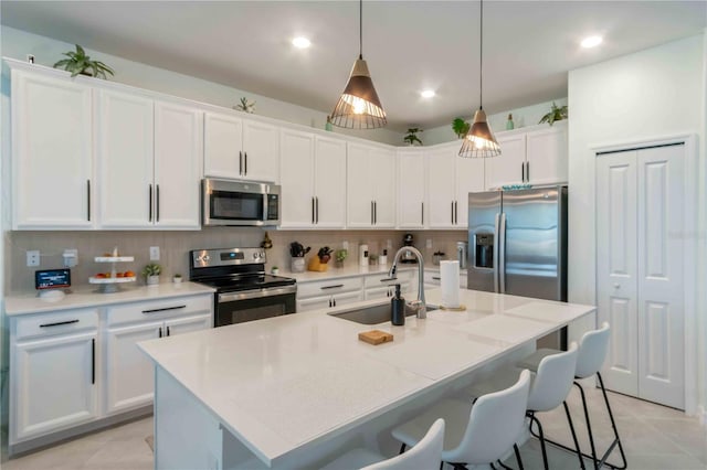 kitchen with a sink, decorative backsplash, white cabinetry, and stainless steel appliances