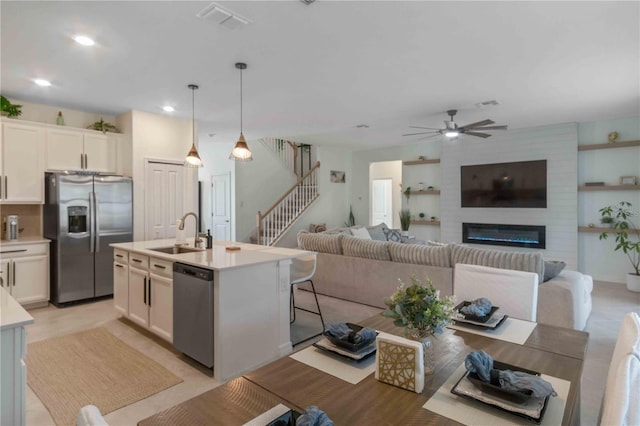 kitchen featuring visible vents, a sink, stainless steel appliances, light countertops, and ceiling fan