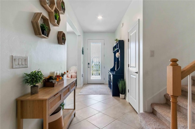 foyer entrance with stairs and light tile patterned flooring