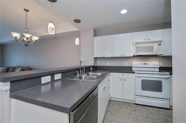 kitchen with white cabinets, sink, white appliances, and kitchen peninsula