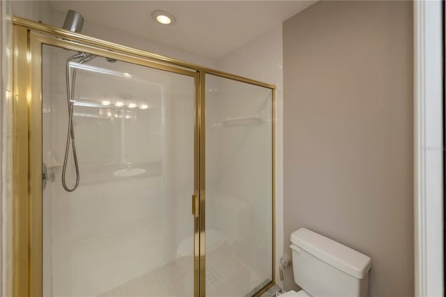 bathroom with toilet and a shower with door