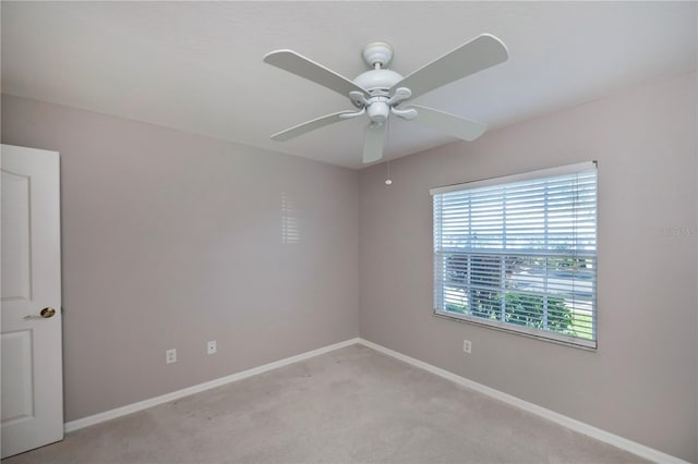 carpeted spare room featuring ceiling fan