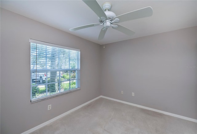 carpeted spare room with ceiling fan