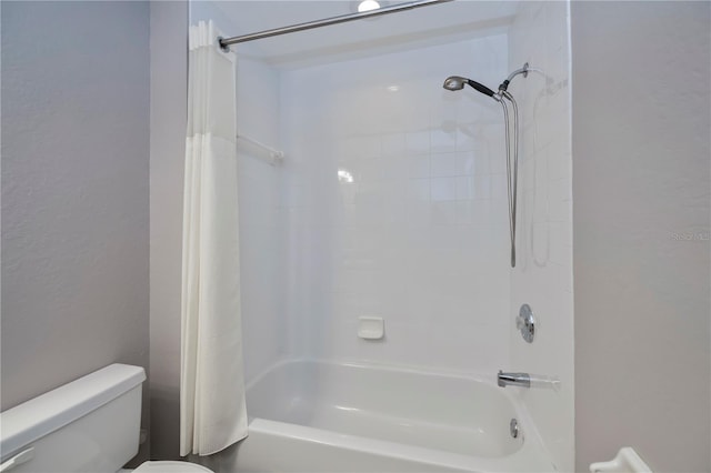 bathroom featuring shower / tub combo with curtain and toilet