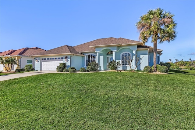 mediterranean / spanish house with a front yard, an attached garage, driveway, and stucco siding