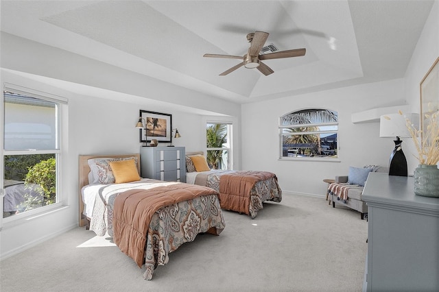 bedroom featuring ceiling fan, light colored carpet, and multiple windows