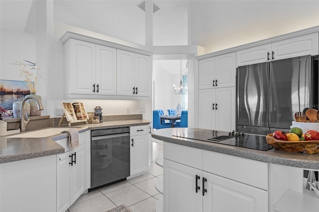 kitchen with stainless steel appliances, sink, light tile patterned floors, pendant lighting, and white cabinetry