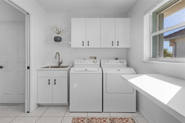 washroom featuring light tile patterned flooring, cabinets, sink, and washing machine and clothes dryer