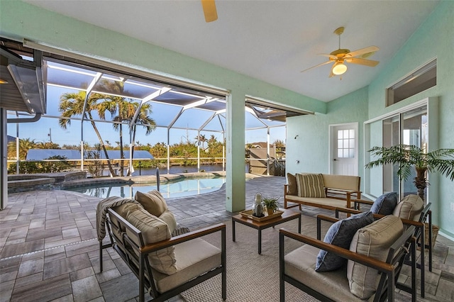 view of patio / terrace with an outdoor living space, ceiling fan, and glass enclosure