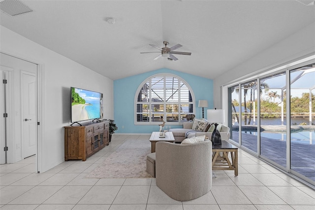 living room featuring visible vents, a ceiling fan, baseboards, light tile patterned flooring, and lofted ceiling