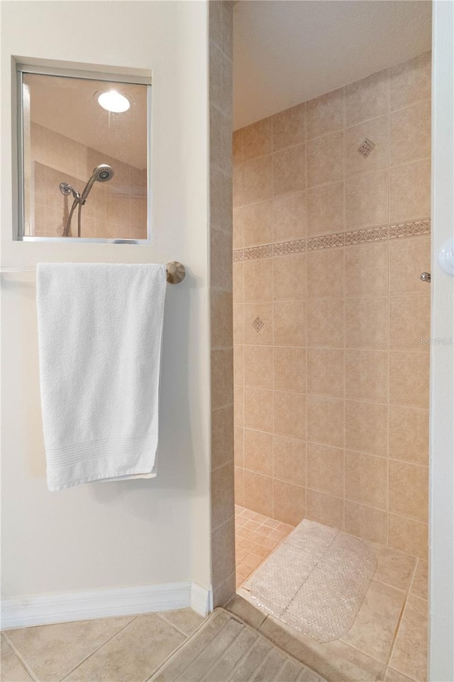 full bath featuring tile patterned flooring, baseboards, and walk in shower