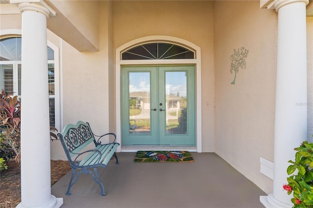 property entrance featuring french doors and stucco siding