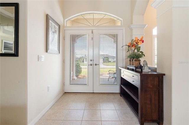 doorway featuring baseboards, light tile patterned flooring, and french doors