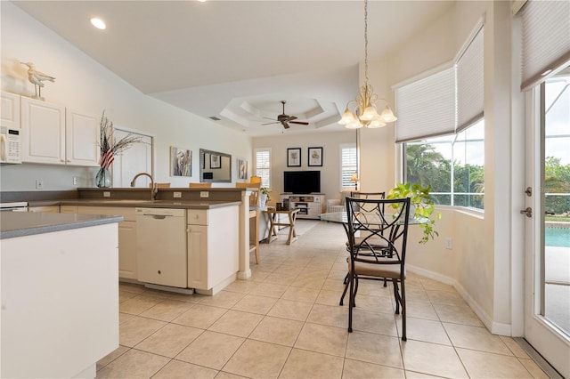 kitchen with dark countertops, white appliances, white cabinetry, and decorative light fixtures