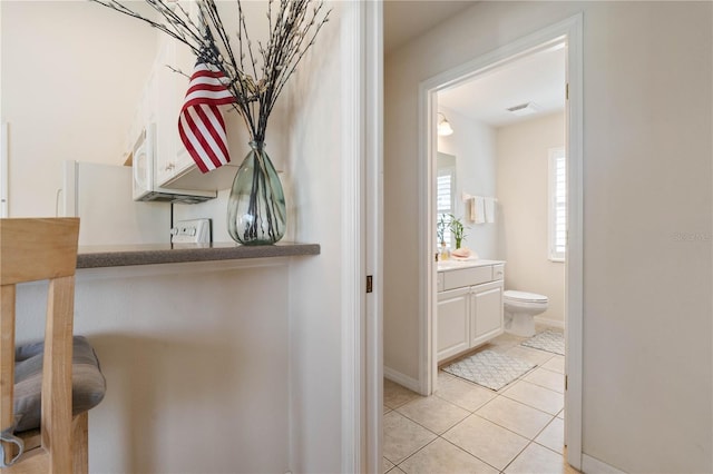 interior space featuring white microwave, baseboards, and visible vents