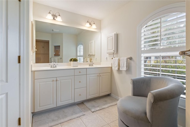 bathroom with tile patterned floors, a sink, baseboards, and double vanity