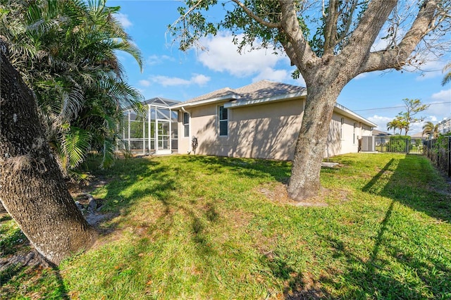 exterior space featuring a lanai, stucco siding, a fenced backyard, and a yard