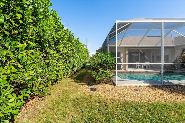 view of yard with glass enclosure and an outdoor pool