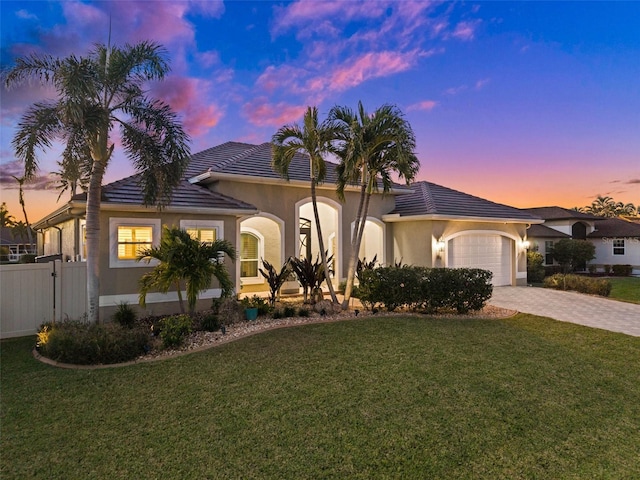 mediterranean / spanish house with a yard and a garage