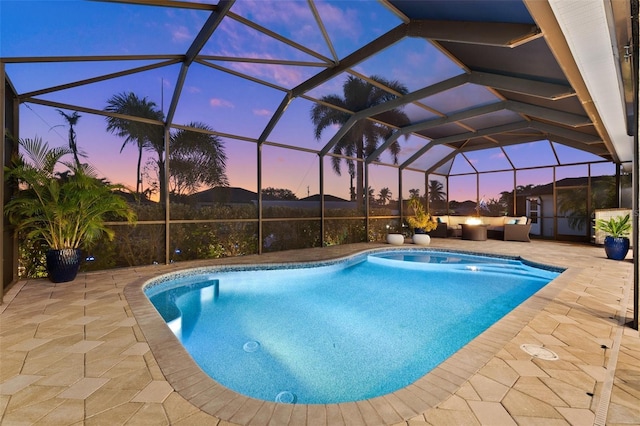 pool at dusk featuring glass enclosure, an outdoor living space, and a patio