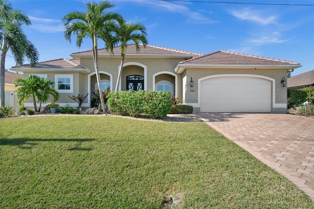 mediterranean / spanish home with a front yard and a garage