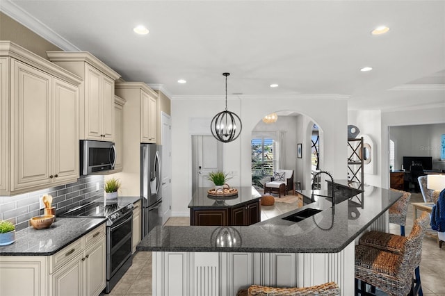 kitchen featuring dark stone counters, a large island, sink, and stainless steel appliances