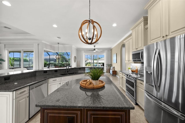 kitchen featuring sink, dark stone countertops, decorative light fixtures, ceiling fan with notable chandelier, and appliances with stainless steel finishes