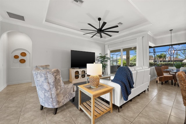 living room featuring a raised ceiling, crown molding, light tile patterned floors, and ceiling fan with notable chandelier