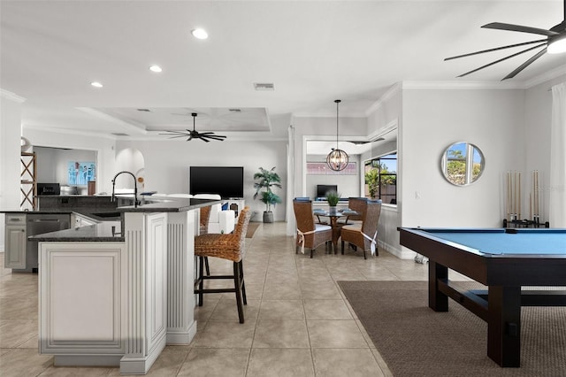 interior space featuring a breakfast bar, hanging light fixtures, billiards, stainless steel dishwasher, and ornamental molding