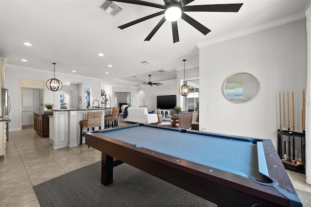 recreation room featuring light tile patterned flooring, ornamental molding, ceiling fan with notable chandelier, and billiards