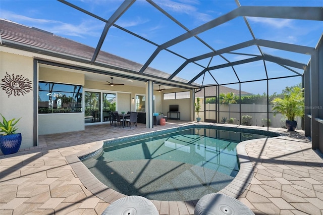 view of swimming pool featuring a patio, glass enclosure, and ceiling fan