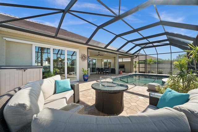 view of swimming pool featuring outdoor lounge area, a patio, glass enclosure, and ceiling fan