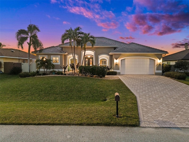 view of front of property featuring a lawn and a garage